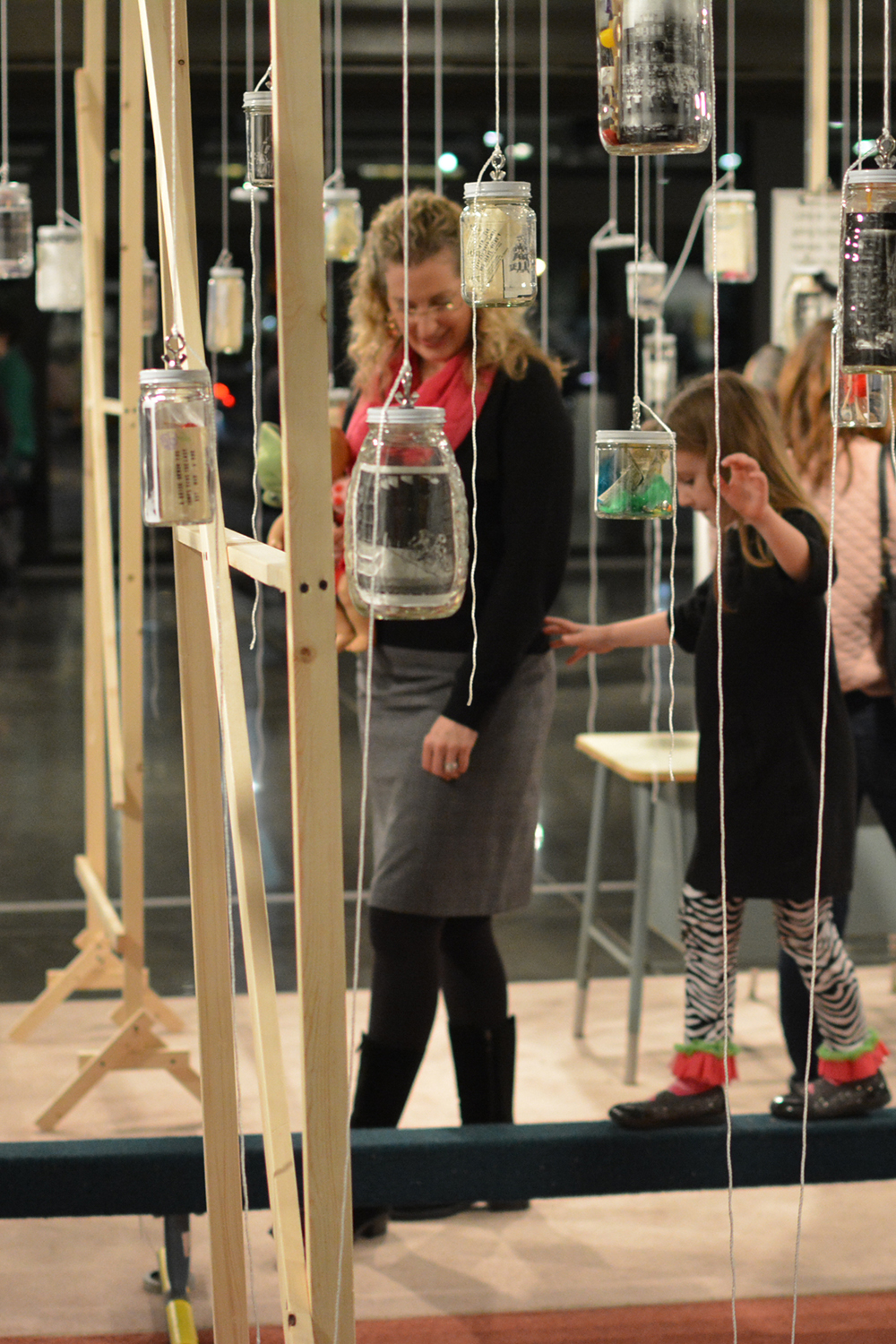 View of the Installation during the Opening Reception, and a visitors walking on the balance beam.
